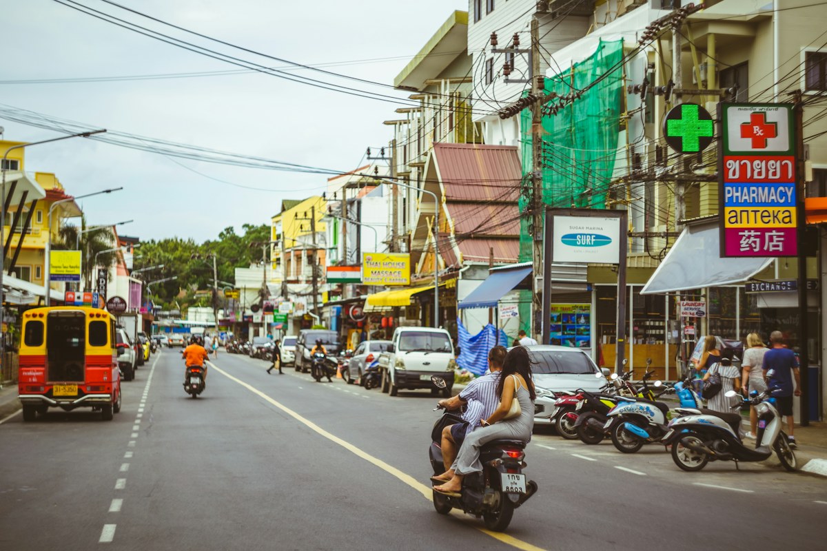 Busy Patong Beach street with scooters and local shops